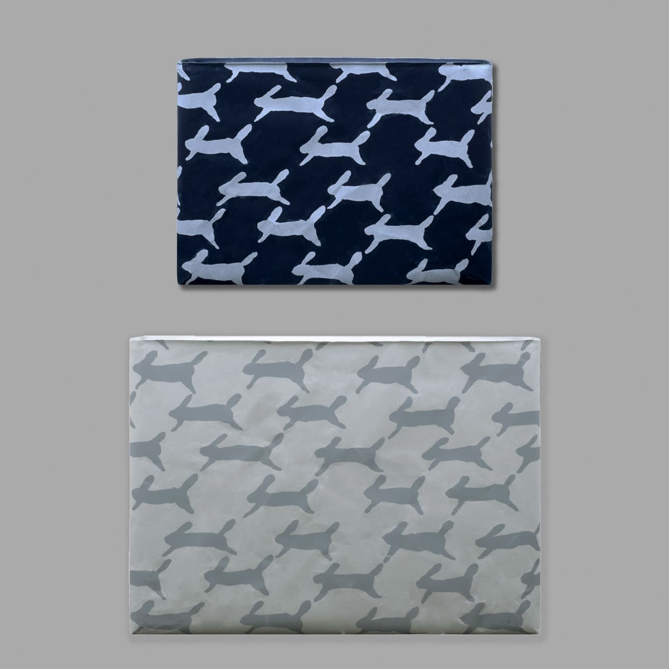 うさぎがモチーフとなった“run run run”の柄、グレイとダークブルーの2色を用意。（上）《PC / タブレットケース iPad》6,820円。W28cm×H21cm×D1.5cm。（下）《PC / タブレットケース M》8,140円。W36cm×H28cm×D1.5cm。