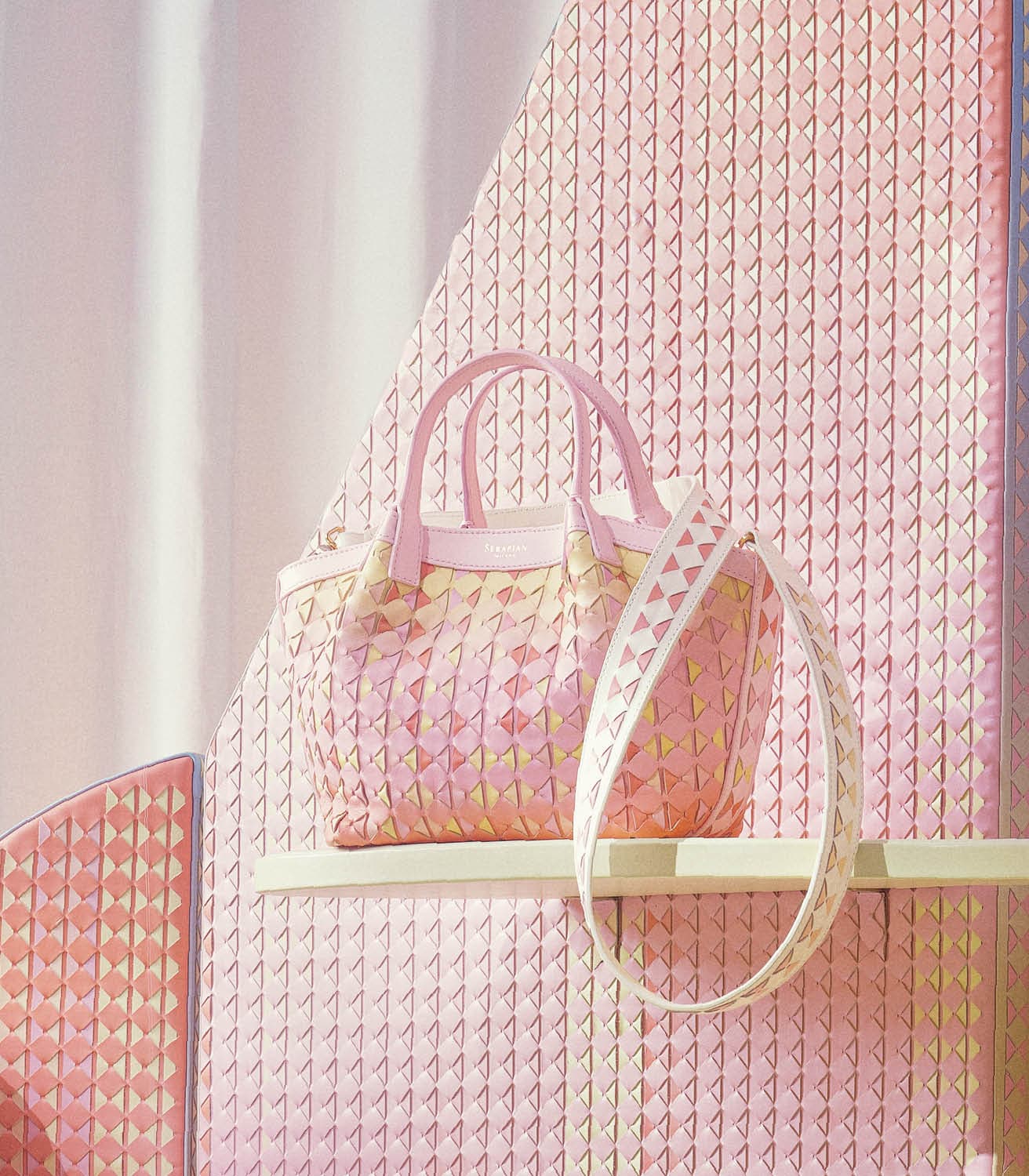 ミニ シークレット バッグ（ピンク）各481,800円。コンパクトながら日常の必需品が収まる便利なバッグ。バッグに付けた別売りストラップ（オフホワイト）85,800円。