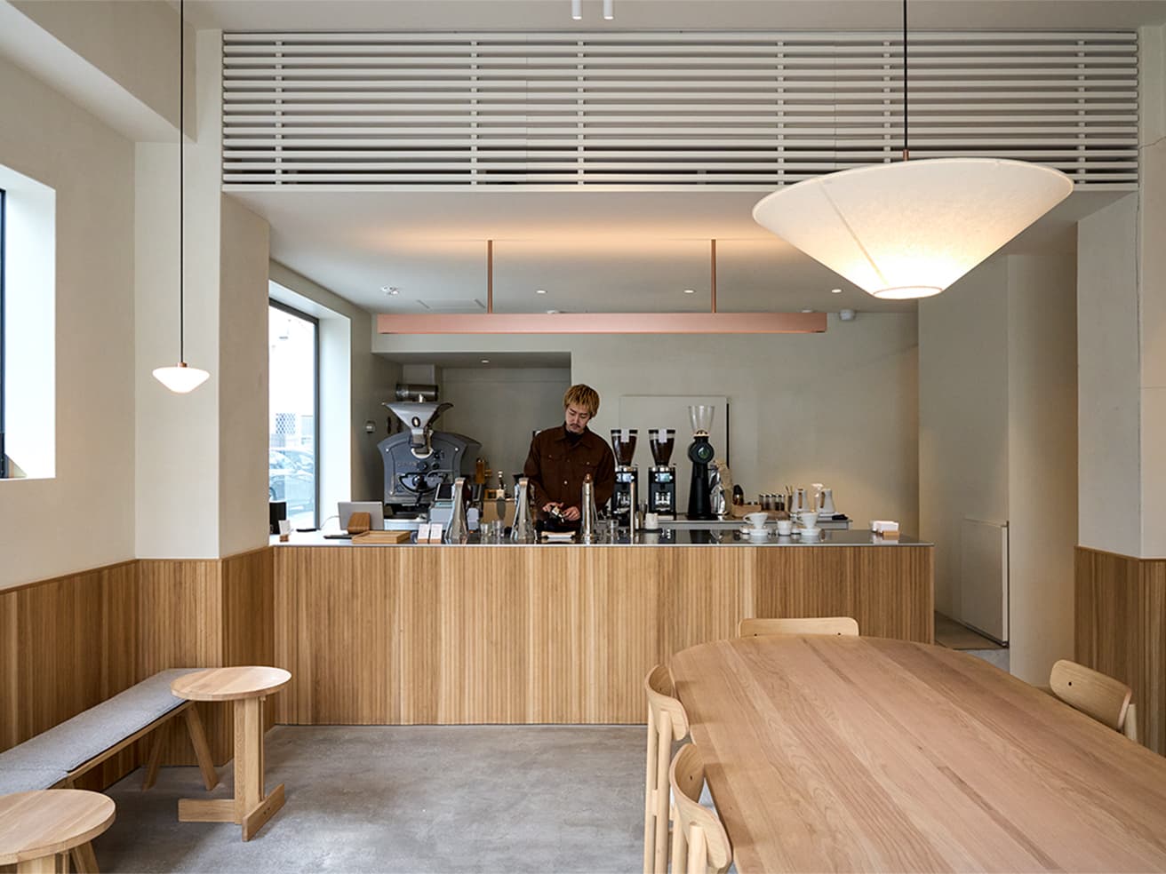 1階に入居する〈dotcom coffee 浅草橋〉は家具や照明まで芦沢がデザイン。