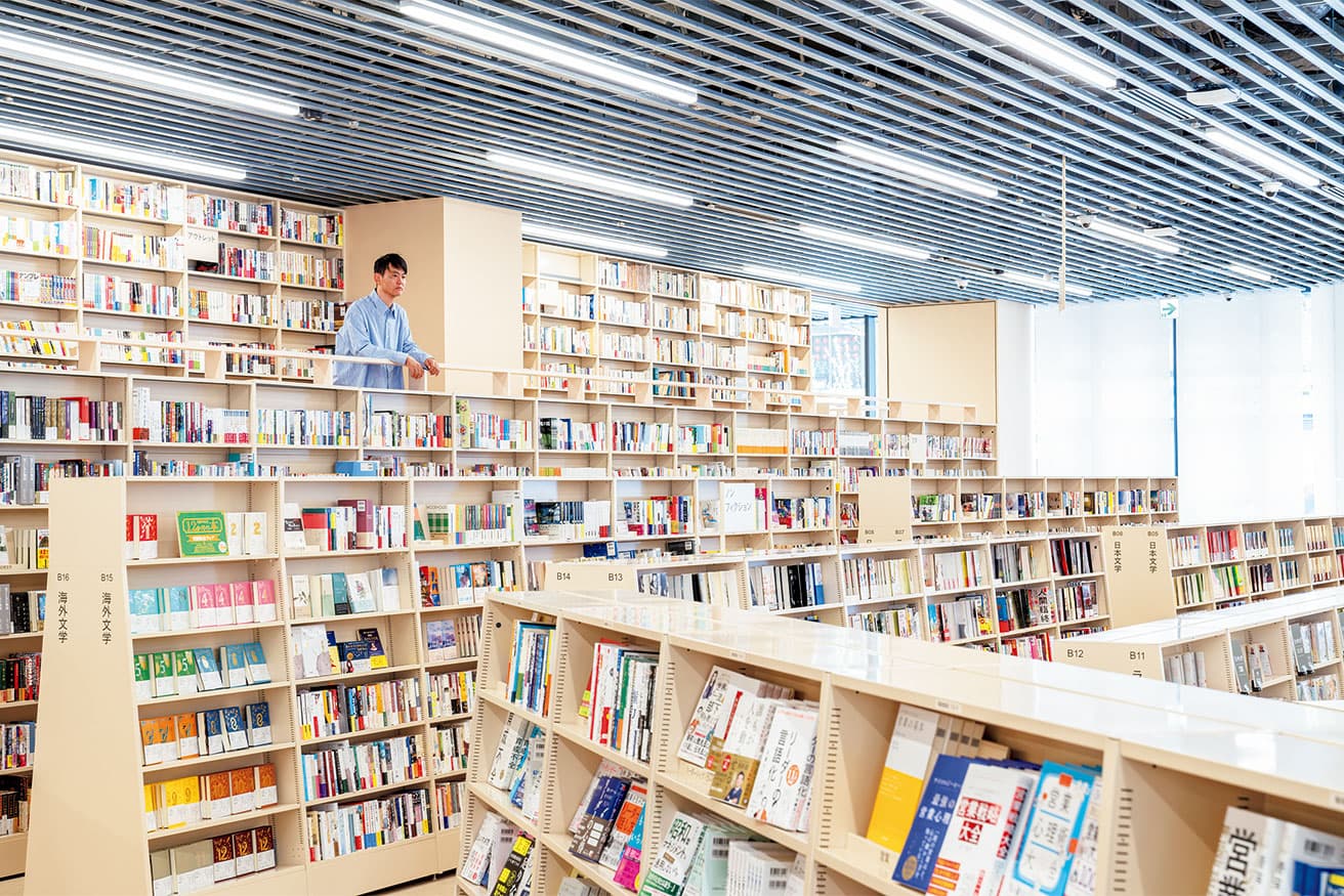 本を引き立てる書棚はベージュをメインに。2、3階の外周部にはグレーを配置。棚に沿って照明を設置するために天井にも工夫が。