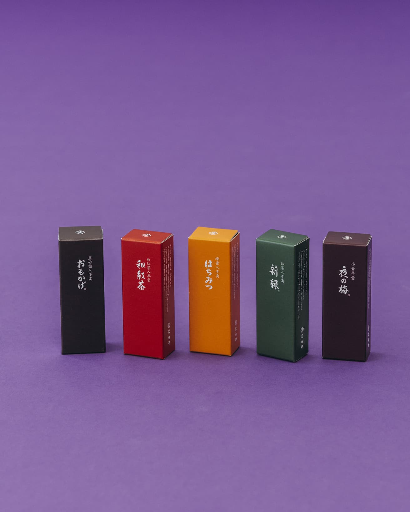 （左から）西表島産の黒砂糖を使用した《おもかげ》、和紅茶と白餡の風味が味わえる《和紅茶》、カナダ産クローバー蜂蜜のコクのある風味と白餡の上品な甘さ《はちみつ》、抹茶の色あいと心地よい苦味が楽しめる《新緑》、とらやを代表する小倉羊羹《夜の梅》。小形羊羹の定番5種が詰め合わせになっている。