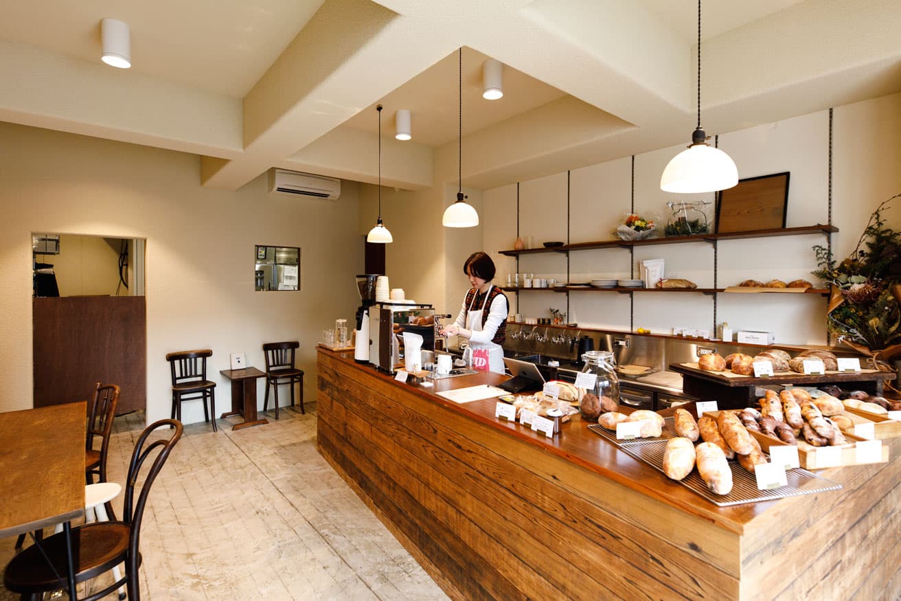 ウッド調の店内に滲む、柔らかな光が作り出す安らぎの空間。カウンター一杯に並ぶパンと焼き菓子がアットホームな雰囲気を拡張している。