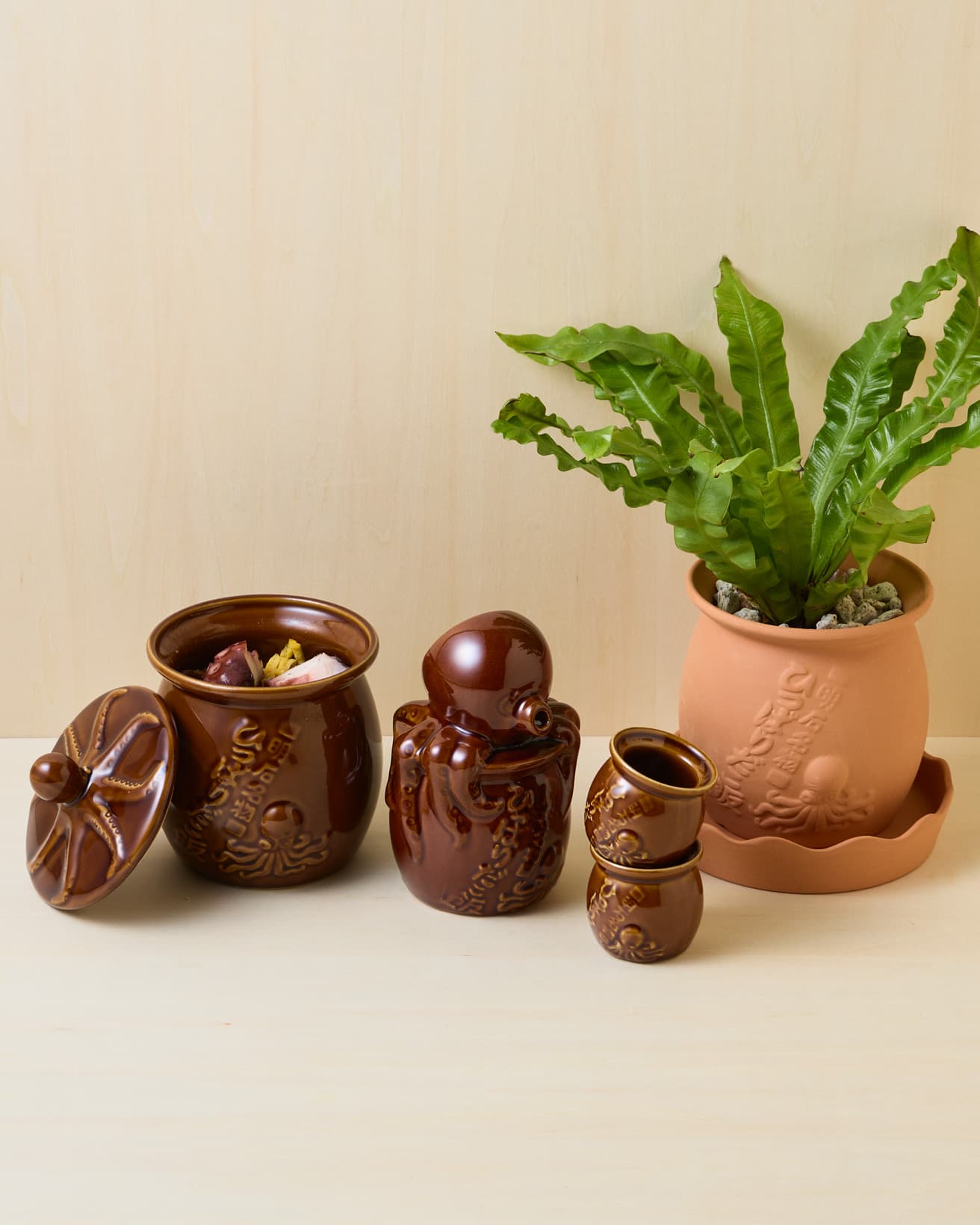 ユニークな見た目ながら、素材やつくりは本格的。インテリアのアクセントにもなりそうだ。(左から)《ひっぱりだこの蓋》680円、《ひっぱりだこ飯》1,480円、《ひっぱりだこの徳利》1,500円、《ひっぱりだこのお猪口》1個680円、《ひっぱりだこの植木鉢》1,500円。